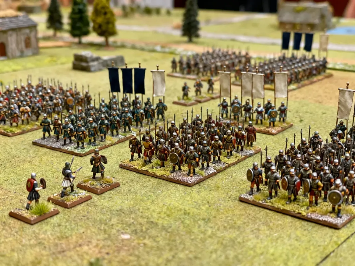 Oddziały figurek 10–15 mm ustawione w formacjach na stole bitewnym